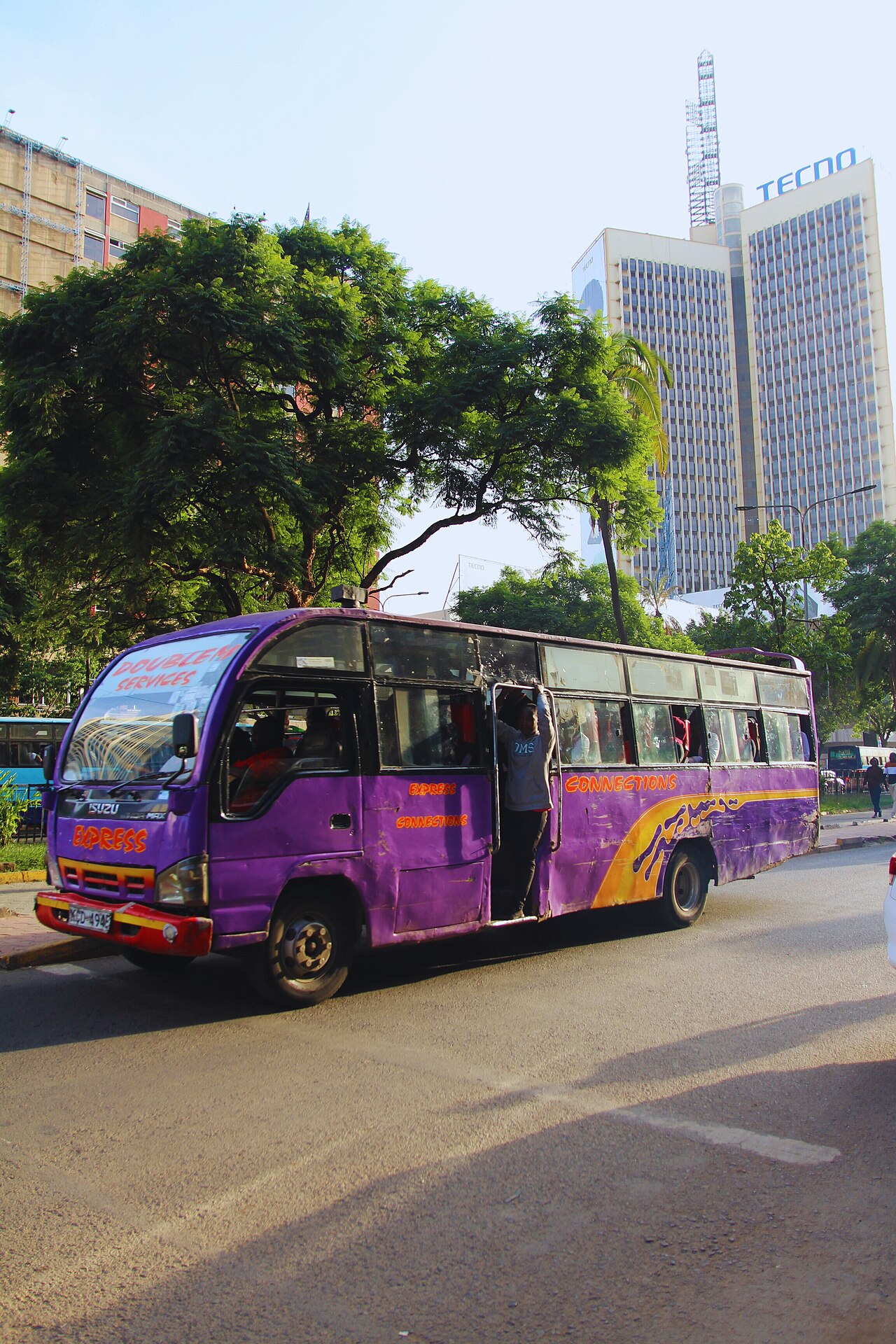 A matatu passing tree-lined streets in Nairobi